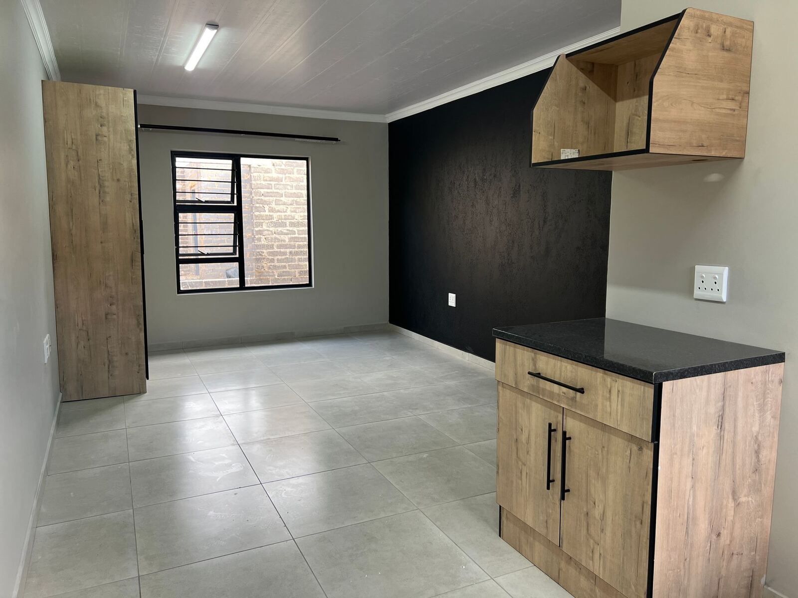 Open-plan living space with a feature wall and kitchen counter