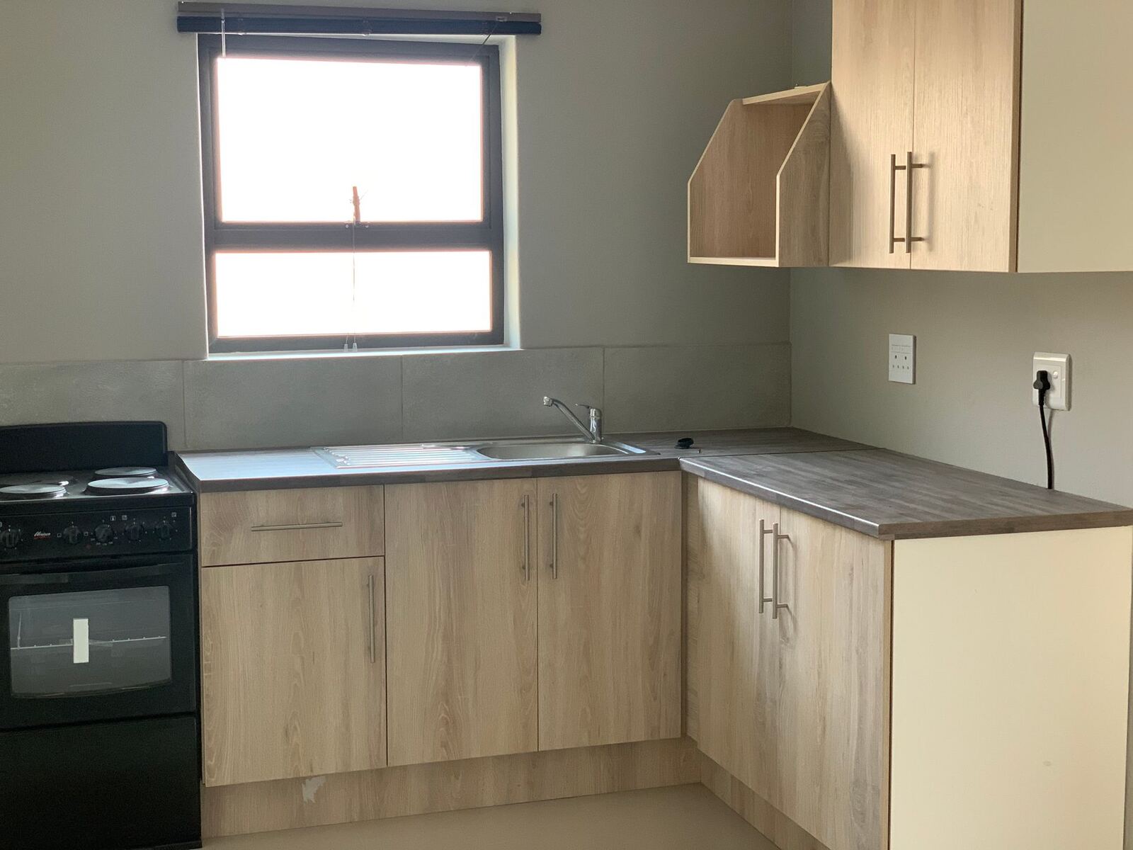 Kitchen corner with black stove under a window