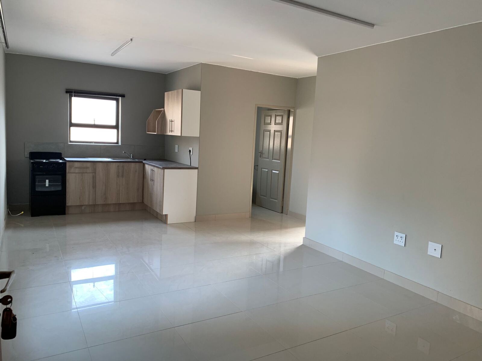 Open-plan unit with tiled floor and kitchen along one wall
